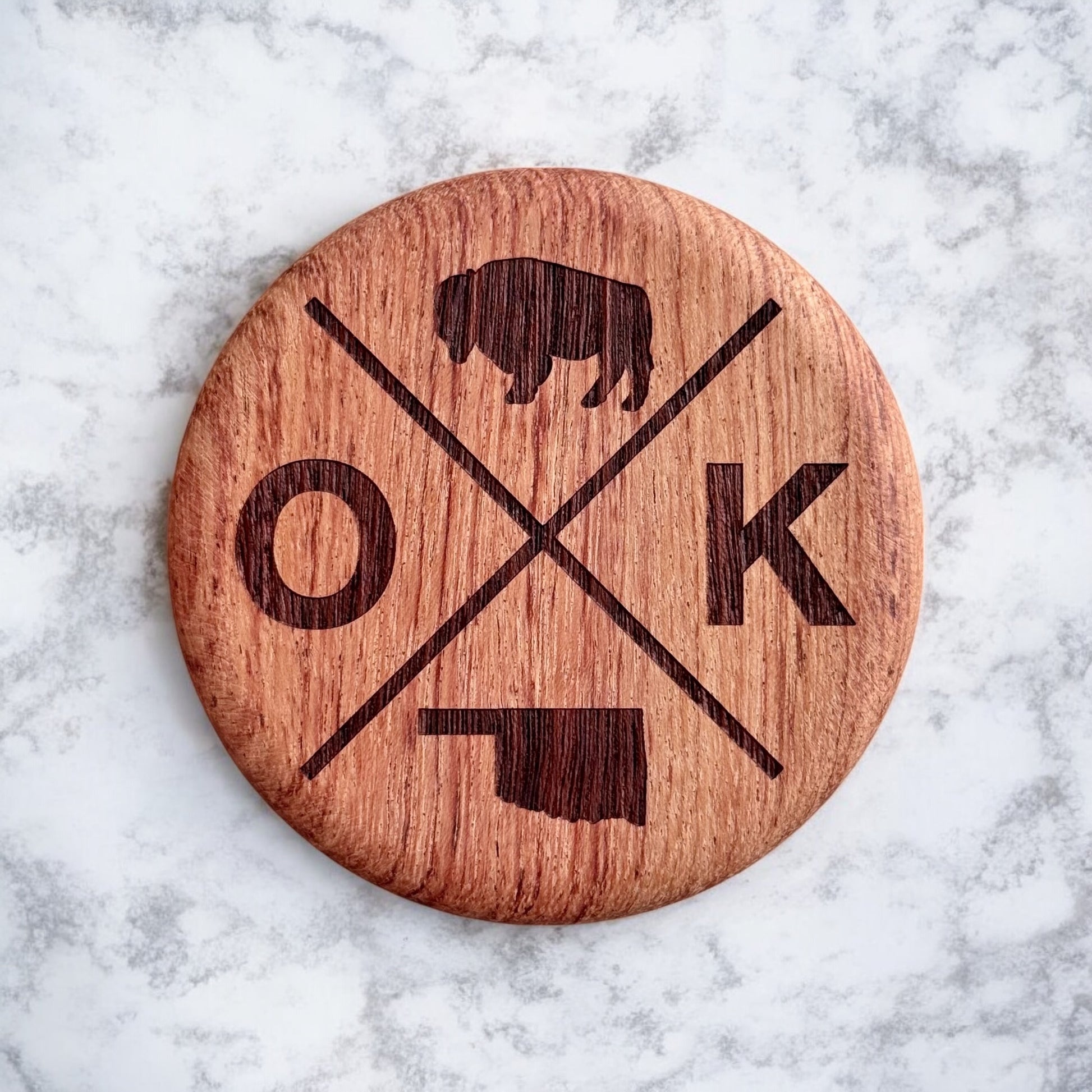 Close up of engraved Oklahoma OK bison design on solid red beechwood round bottle opener magnet, rustic Oklahoma kitchen and bar accessory gift