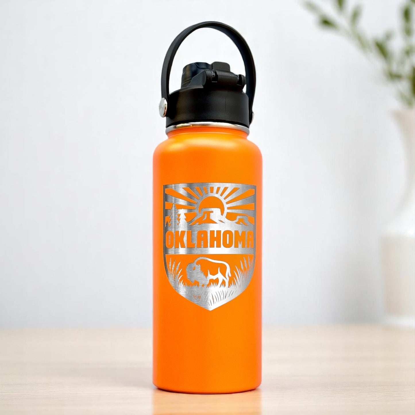 Orange Oklahoma outdoor adventure insulated water bottle with engraved bison and landscape shield design