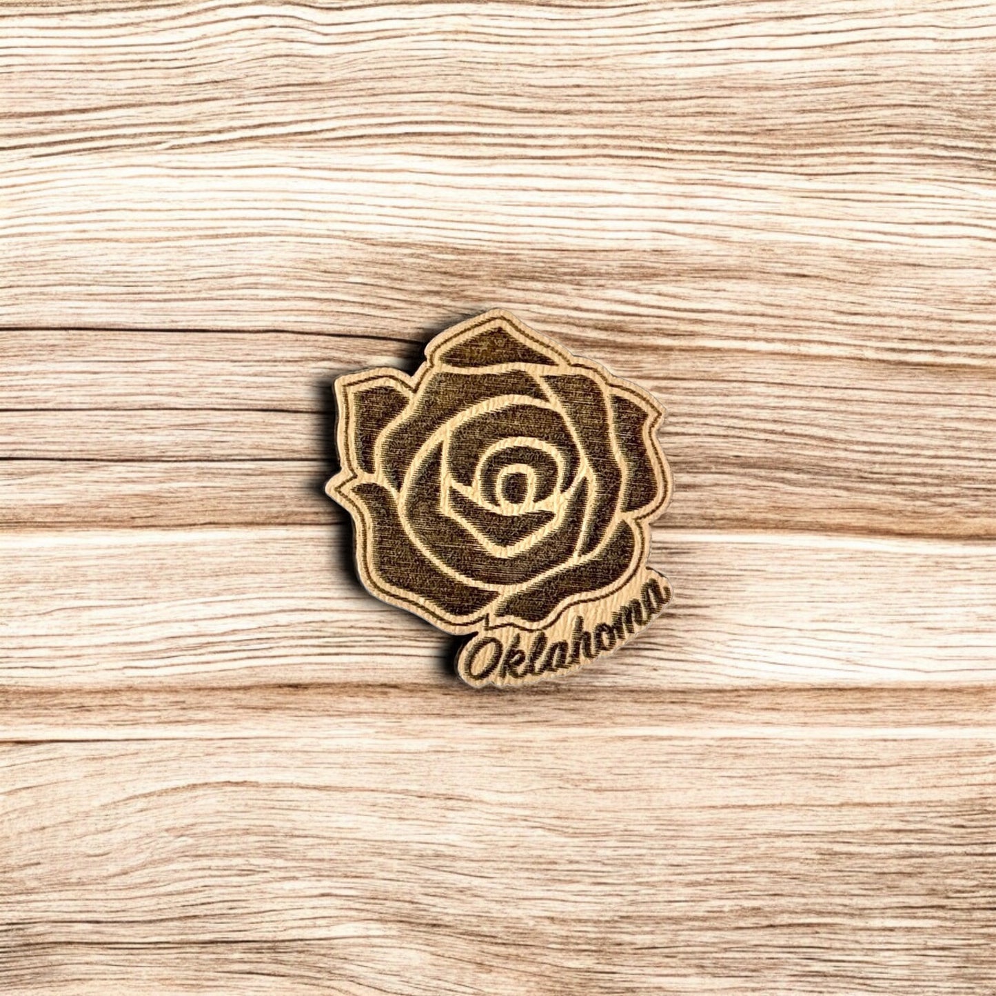 Oklahoma rose wooden lapel pin showing engraved rose design with Oklahoma script, laser cut wood pin used as Oklahoma souvenir or state pride accessory