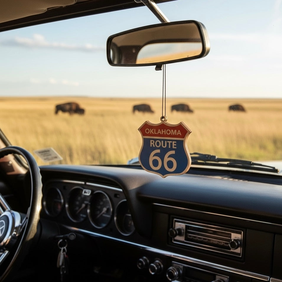 Oklahoma Route 66 shield wood ornament hanging from a car rearview mirror with Oklahoma prairie and bison in background, Americana road trip decor inspired by historic Route 66 travel