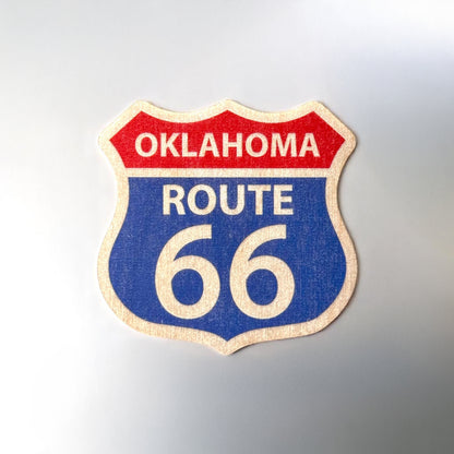 Oklahoma Route 66 wooden veneer sticker displayed on a flat surface showing shield shape, bold printed colors, smooth edges, and natural wood grain border