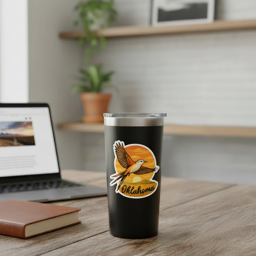 Oklahoma scissortail flycatcher sunset sticker applied to a black insulated tumbler on a desk, colorful Oklahoma state bird decal used as a travel souvenir and local pride gift.