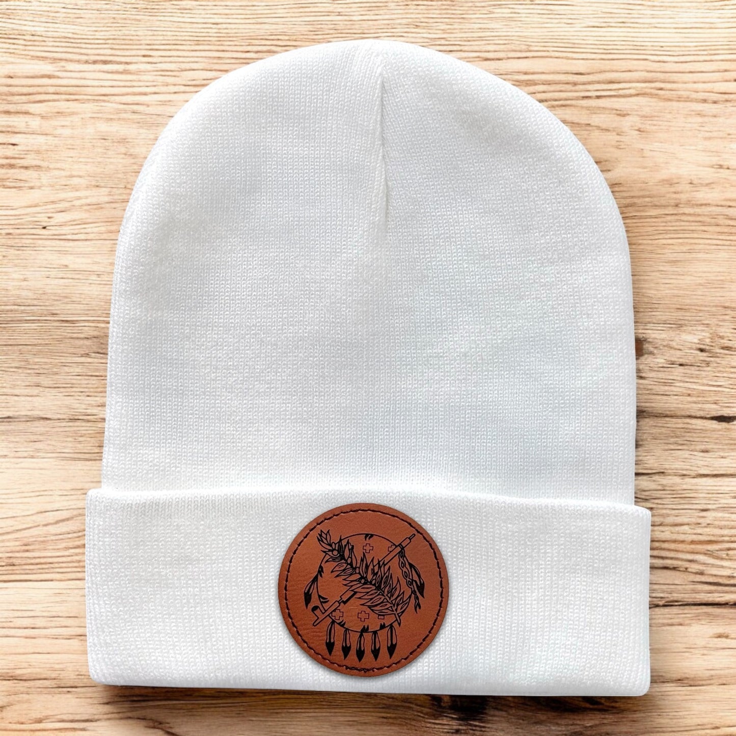 White Oklahoma symbol beanie displayed on wood background, knit cuffed hat with engraved leatherette patch for Oklahoma souvenir gift