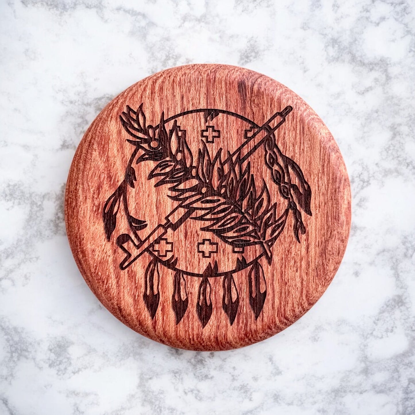 Close-up of round cherry wood magnetic bottle opener with intricate laser engraving of Oklahoma state emblem