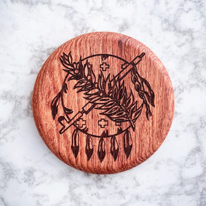 Close-up of round cherry wood magnetic bottle opener with intricate laser engraving of Oklahoma state emblem