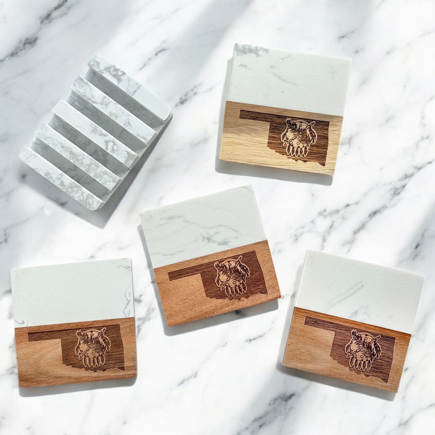 Set of four Oklahoma-themed coasters with marble and acacia wood, shown with a matching marble display base on a white marble surface.