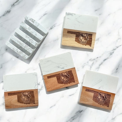 Set of four Oklahoma-themed coasters with marble and acacia wood, shown with a matching marble display base on a white marble surface.