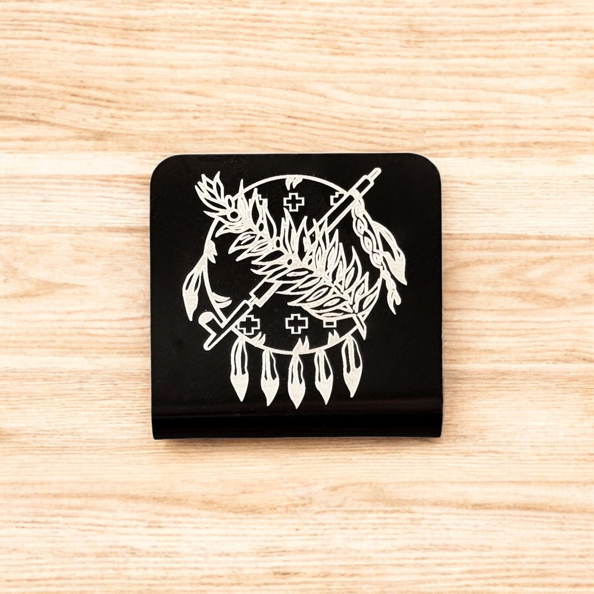 Flat lay of aluminum Oklahoma symbol hat clip showing square shape, black powder coat, and detailed engraved design
