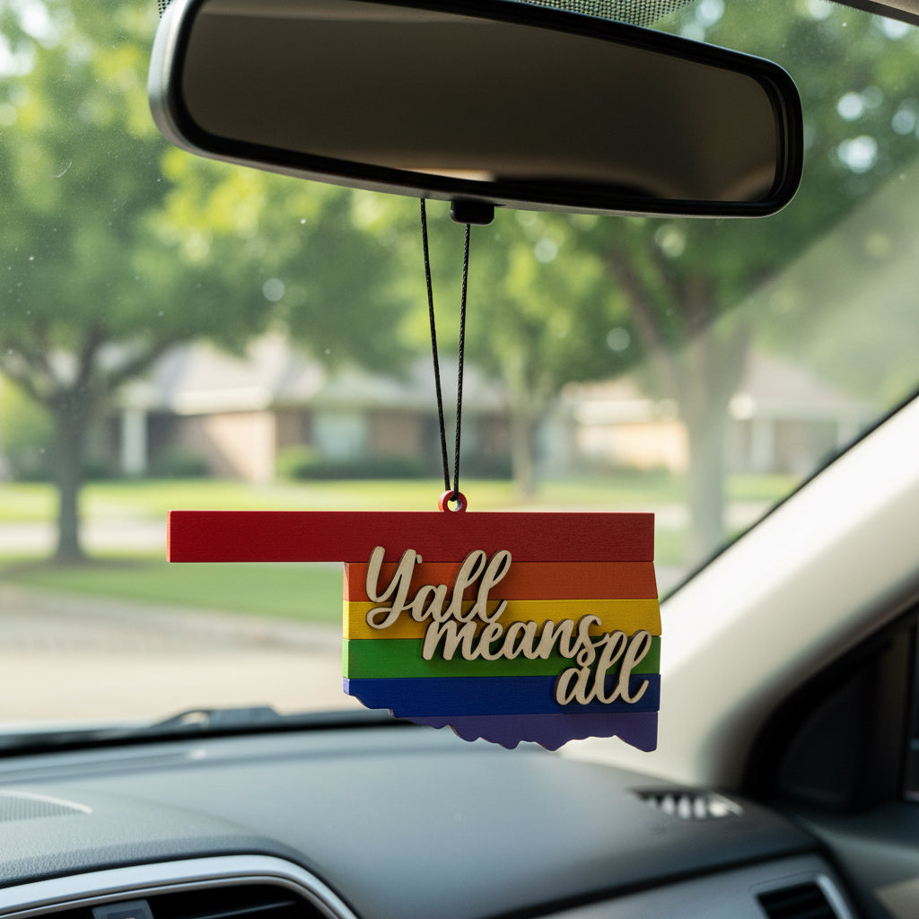 Wooden Oklahoma Yall Means All car ornament hanging from rearview mirror, state silhouette with rainbow pride stripes and layered script lettering, lightweight auto accessory gift supporting inclusion for Oklahoma locals, Route 66 travelers, and USA road trip souvenir collectors