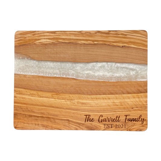 Olive wood cutting board with white resin inlay and custom engraved family name, solid wood board with natural grain and modern resin design
