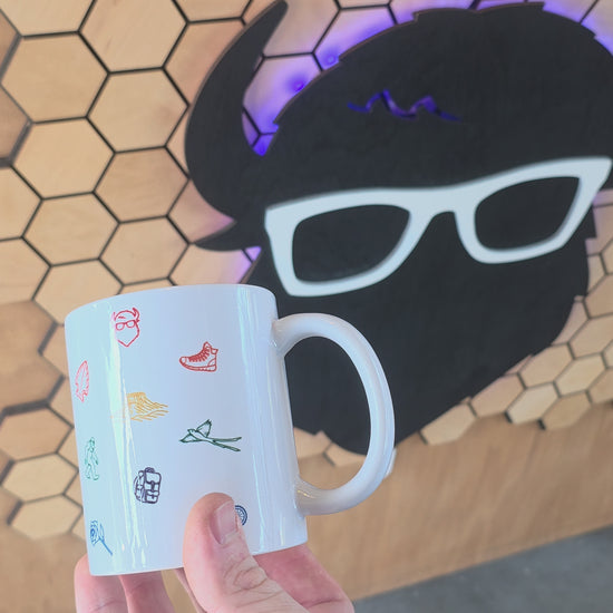 ceramic coffee mug with colorful Oklahoma icons including bison, rose, scissortail, and Gloss Mountains.