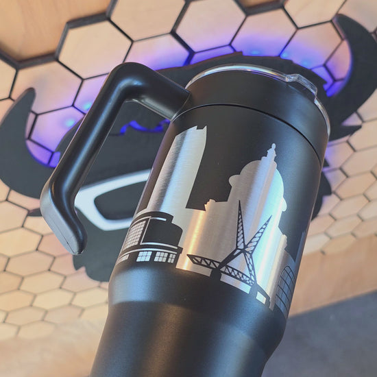 video showing Black Oklahoma City Skyline 30oz handle tumbler with engraved stainless design, handcrafted OKC travel mug by The Curious Bison.