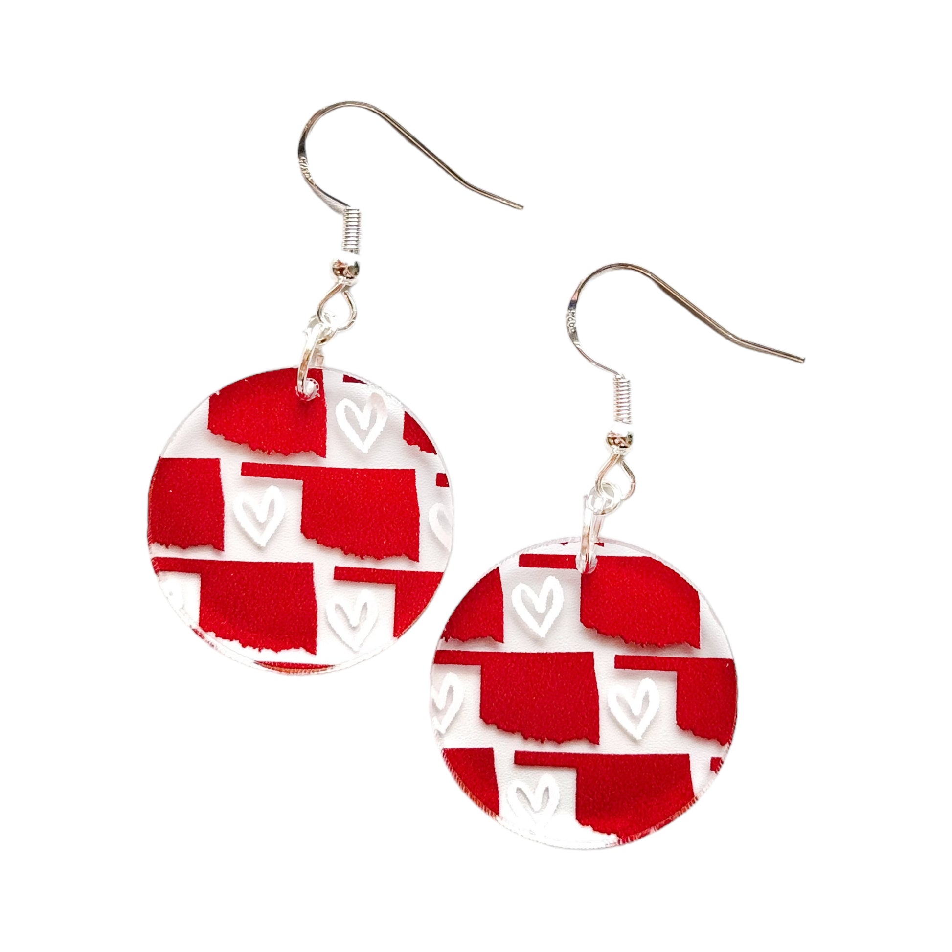 Round red Oklahoma acrylic earrings on white background showing printed Oklahoma state outline and heart pattern with hypoallergenic hooks