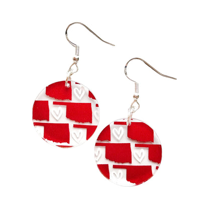 Round red Oklahoma acrylic earrings on white background showing printed Oklahoma state outline and heart pattern with hypoallergenic hooks