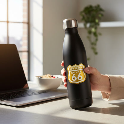 Brushed gold Route 66 100 years vinyl sticker displayed on black reusable water bottle beside laptop, retro Route 66 souvenir decal for travelers and everyday use