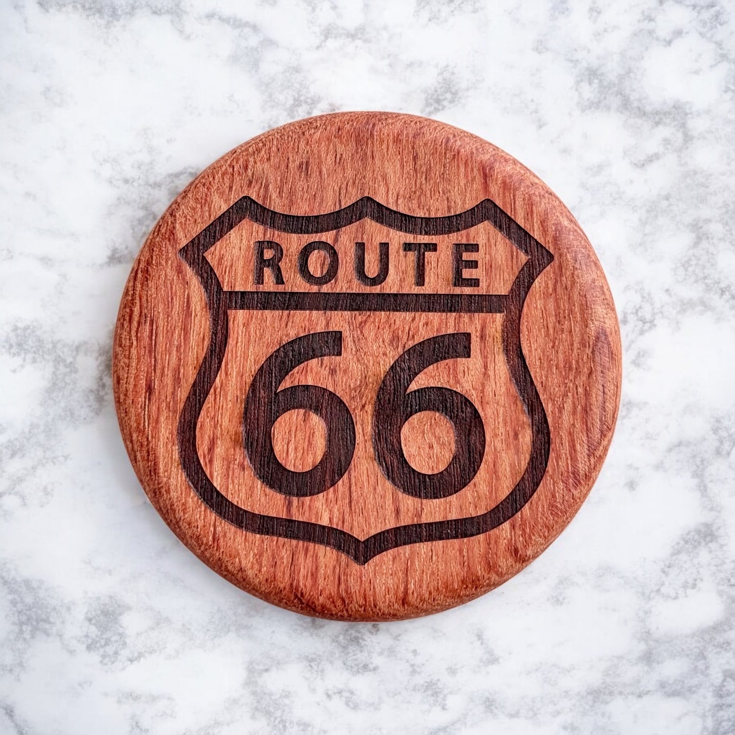 Front view of a round cherry wood bottle opener with a laser-engraved Route 66 highway sign design