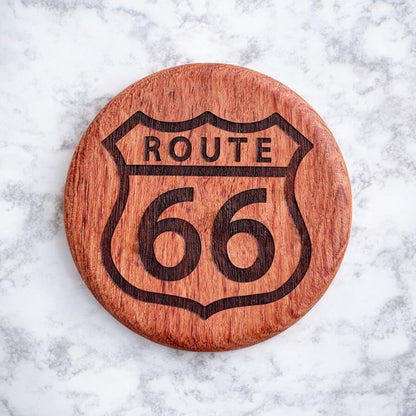 Front view of a round cherry wood bottle opener with a laser-engraved Route 66 highway sign design