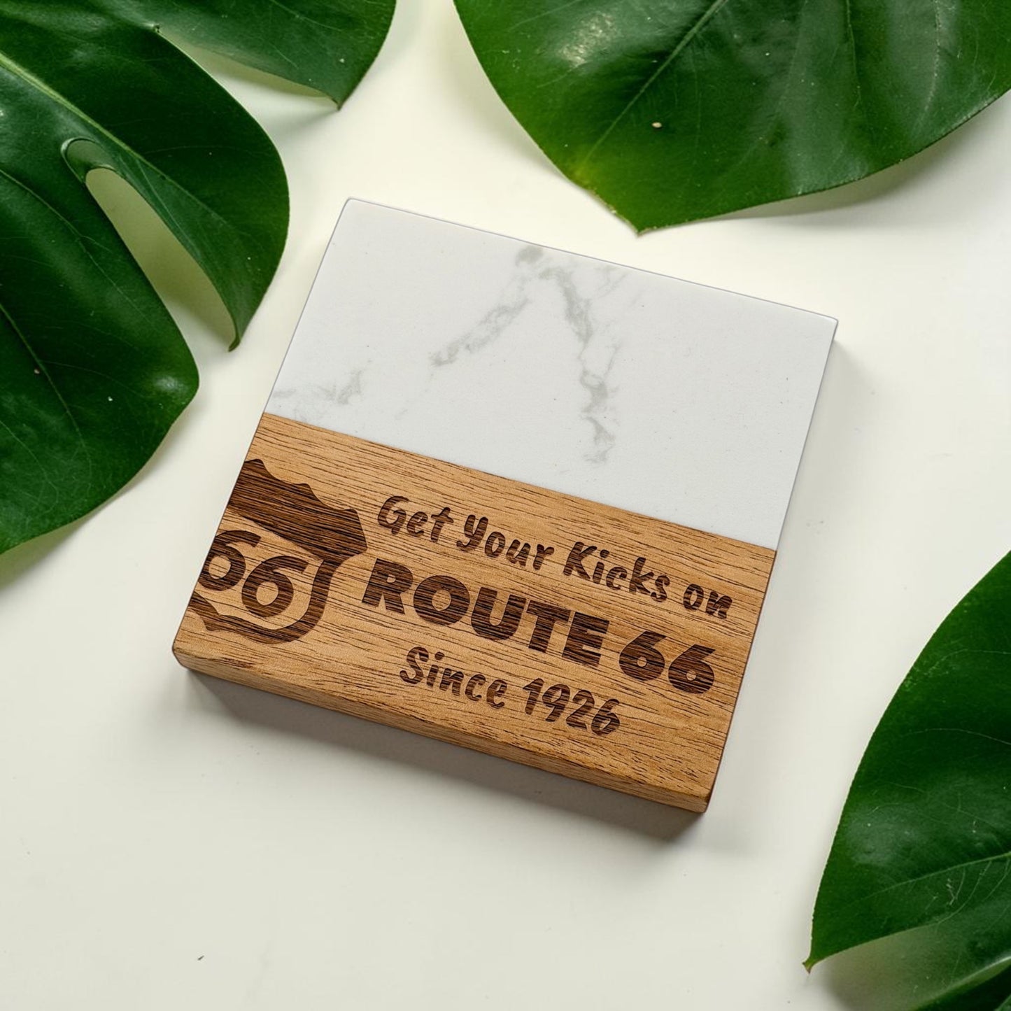 Route 66 marble and wood coaster with engraved Get Your Kicks on Route 66 Since 1926 design displayed on white background with green leaves, vintage Route 66 souvenir coaster for travelers and road trip gifts