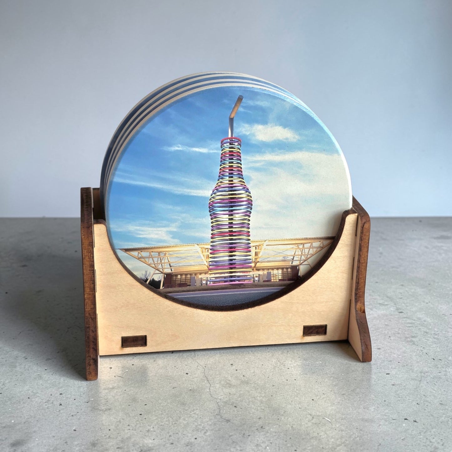 Front view of stacked Route 66 Pops ceramic coasters in wooden holder showing colorful soda bottle landmark design from historic Route 66 Oklahoma