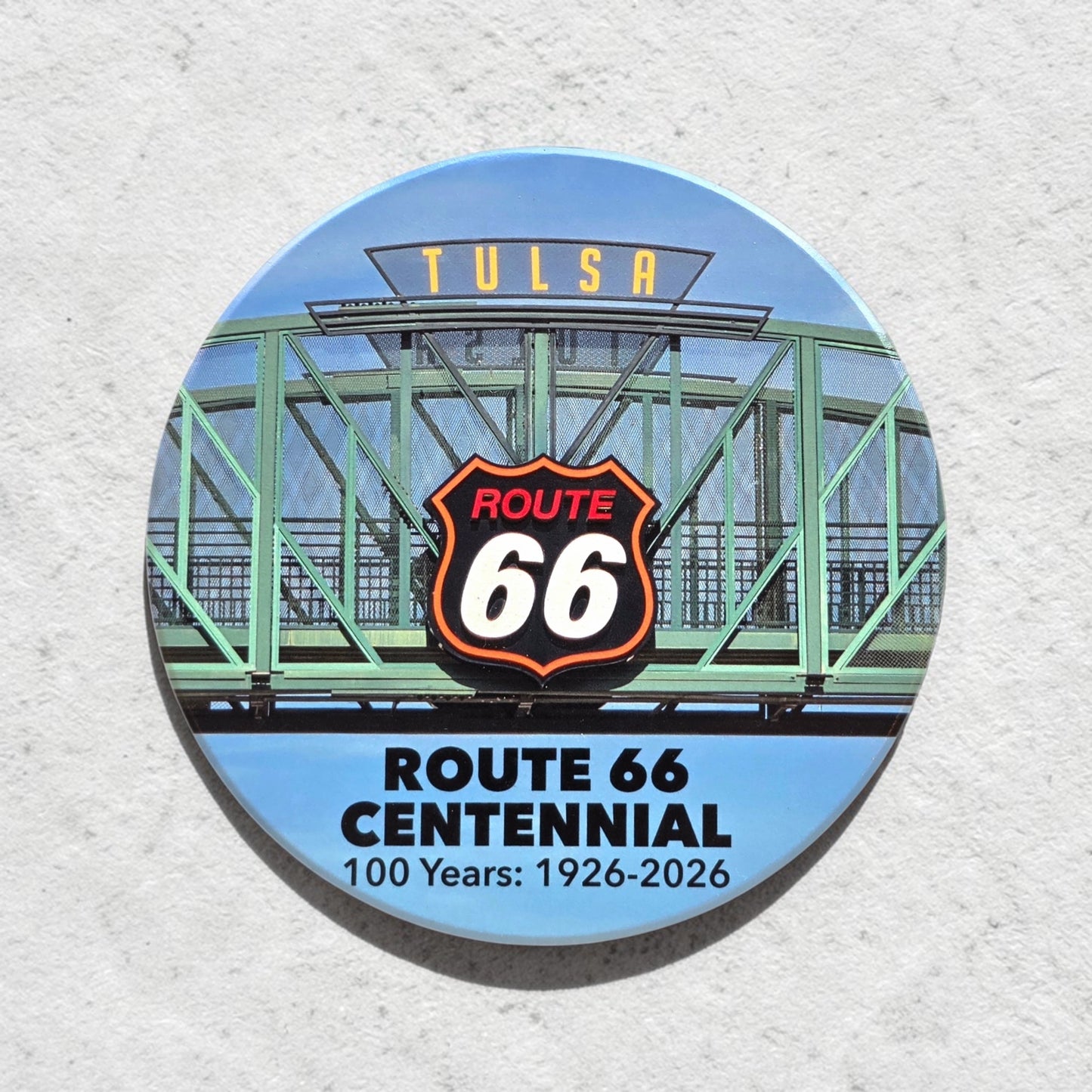 Route 66 Tulsa bridge sign ceramic coaster shown against textured wall, colorful Tulsa souvenir coaster with iconic Oklahoma Route 66 artwork