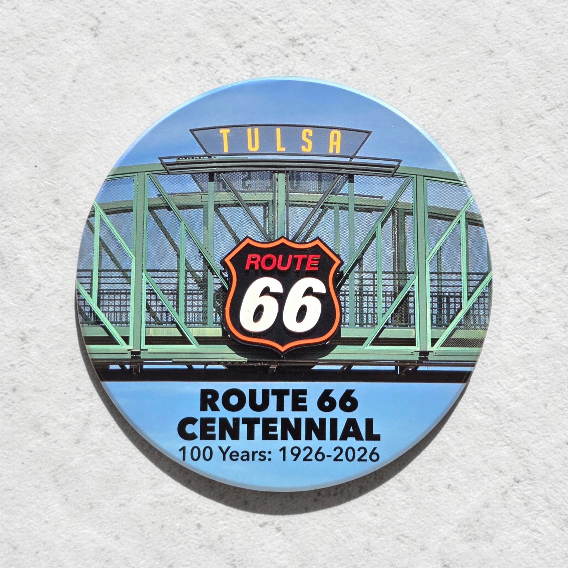 Route 66 Tulsa bridge sign ceramic coaster shown against textured wall, colorful Tulsa souvenir coaster with iconic Oklahoma Route 66 artwork