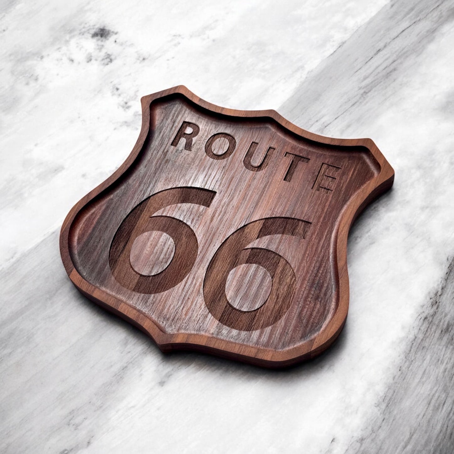 Angled view of Route 66 walnut catch all tray showing raised edge and engraved Route 66 badge design, handcrafted walnut tray