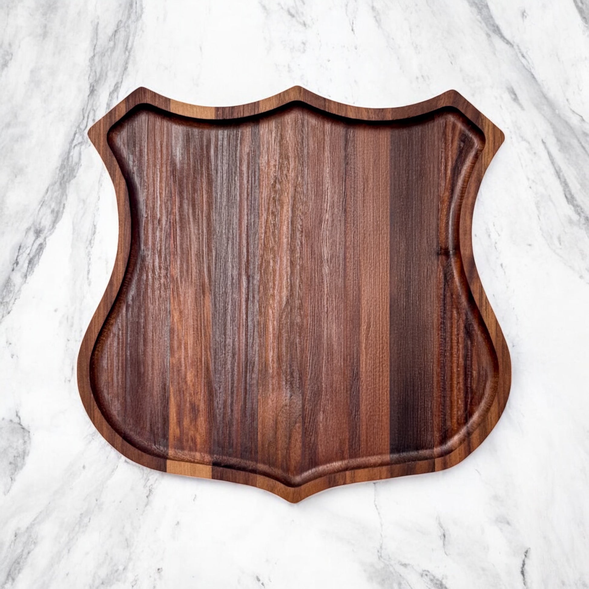 Flat lay of Route 66 badge shaped walnut catch all tray on light surface, solid walnut wood organizer tray for desk, nightstand, or entry table