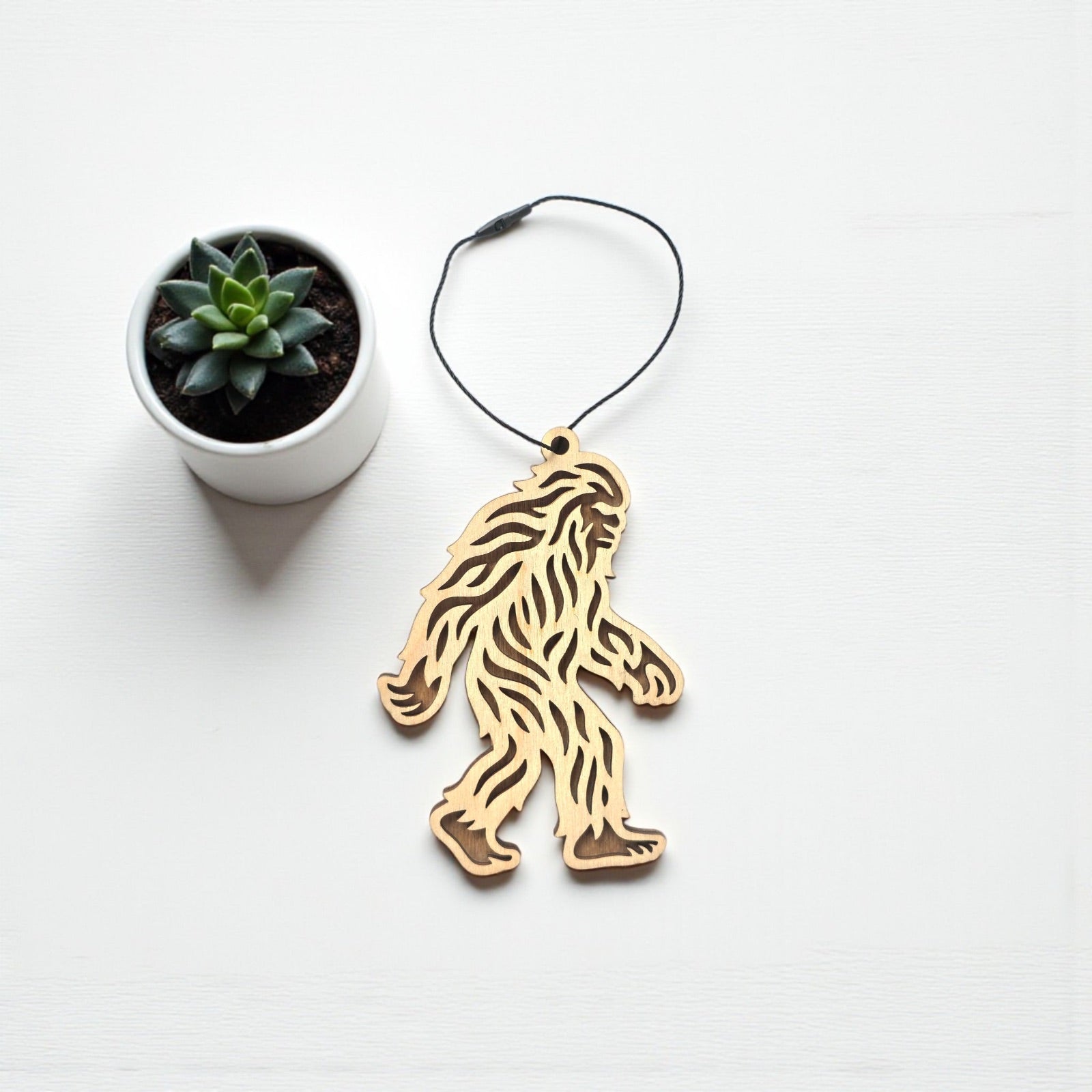 Flat lay of Bigfoot Sasquatch wooden ornament showing detailed cutout texture, natural wood ornament designed as a novelty gift or souvenir