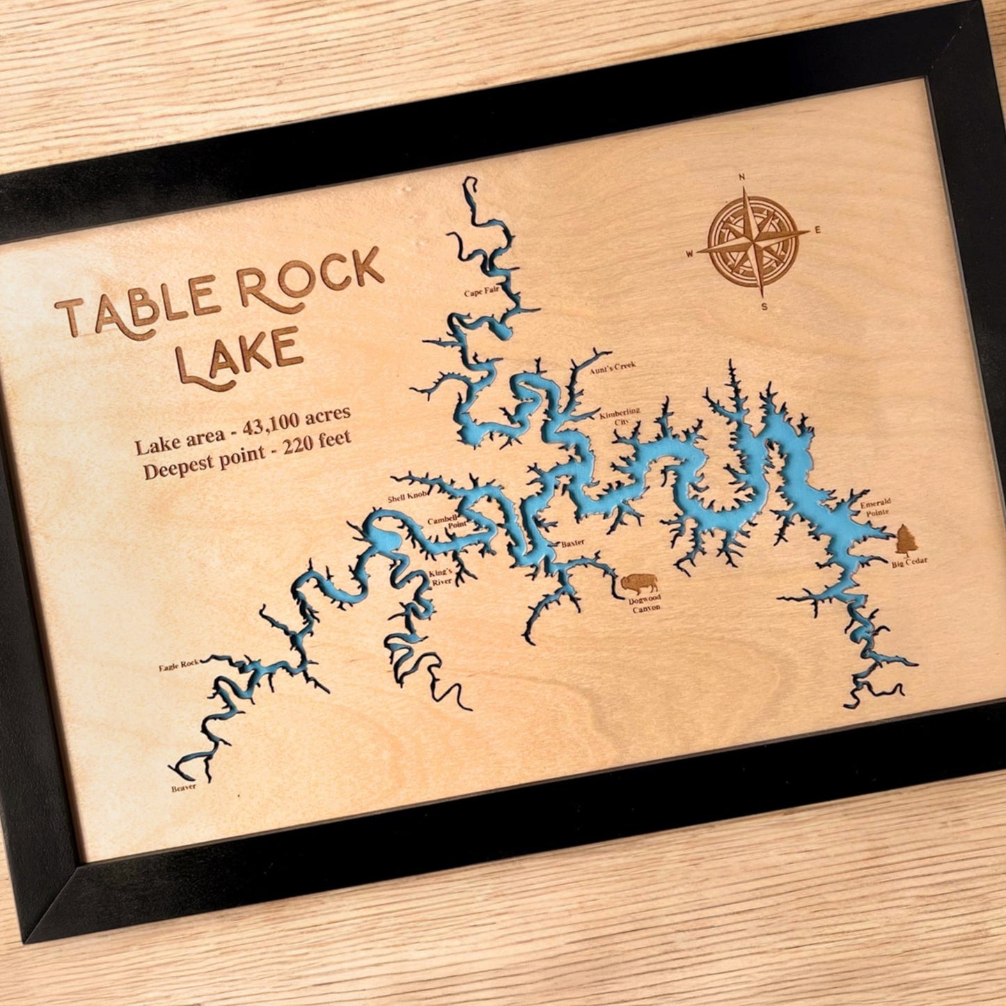 Close up angled view of Table Rock Lake wooden map showing laser cut shoreline, engraved text, and blue layered water detail