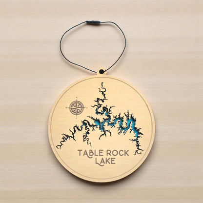 Flat lay of Table Rock Lake in Missouri layered wooden ornament showing engraved lake name, compass detail, and blue painted water layer beneath laser cut wood top
