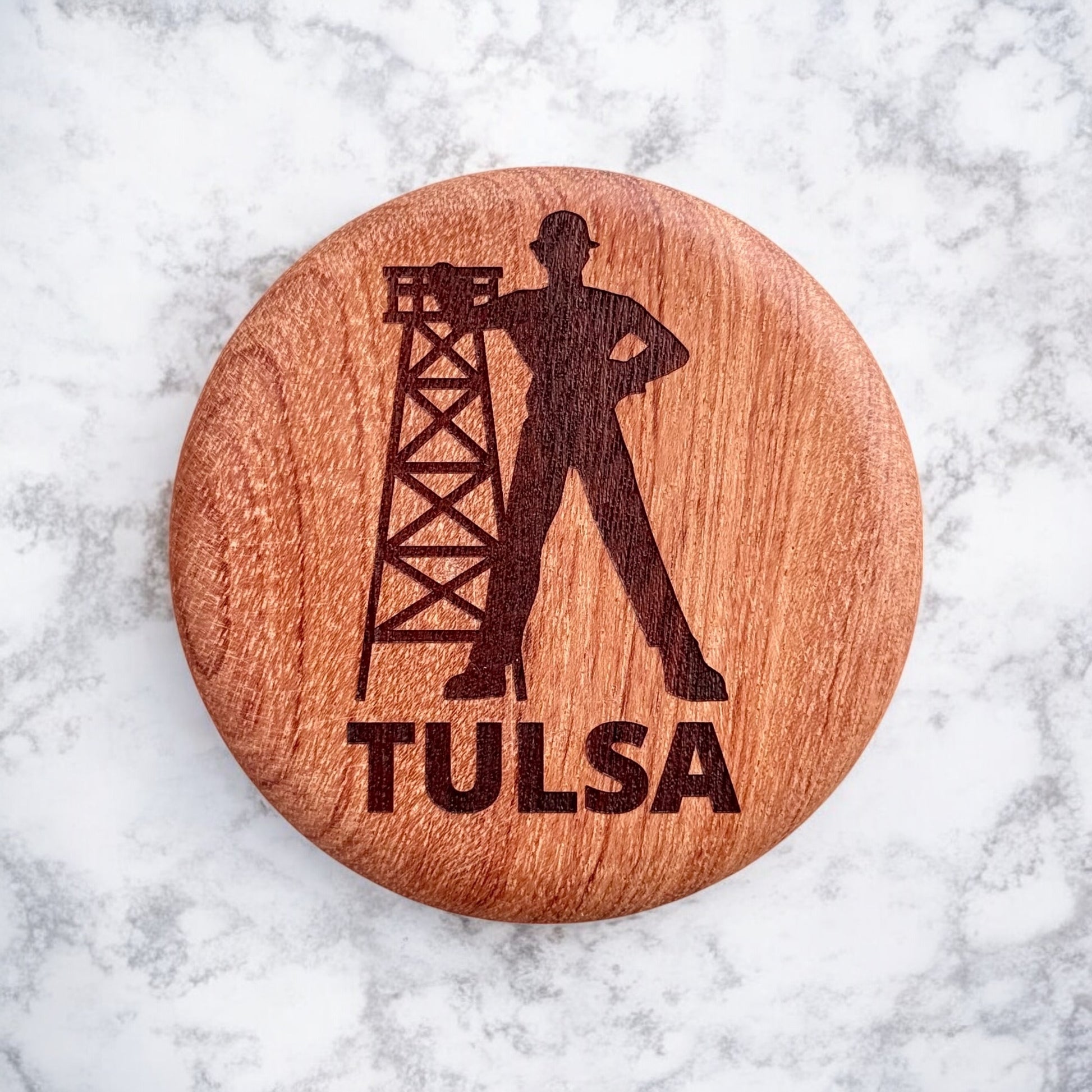 Close up of Tulsa Driller laser engraving on red beech wood magnetic bottle opener with visible wood grain, Oklahoma souvenir