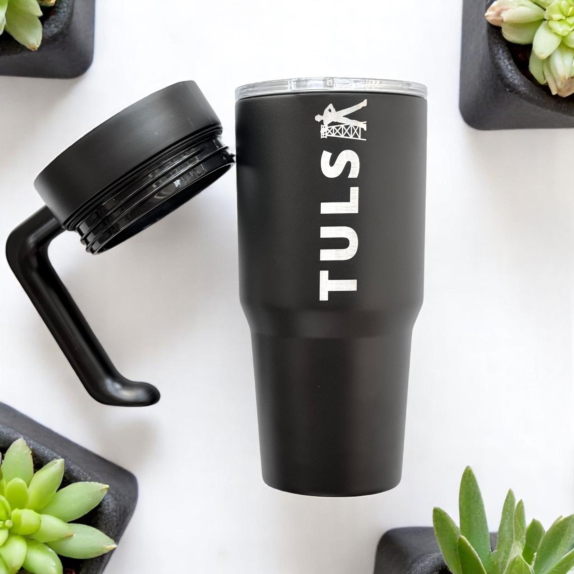 Black Tulsa Driller 30oz tumbler with detachable handle and lid shown separately, stainless steel insulated Tulsa drinkware