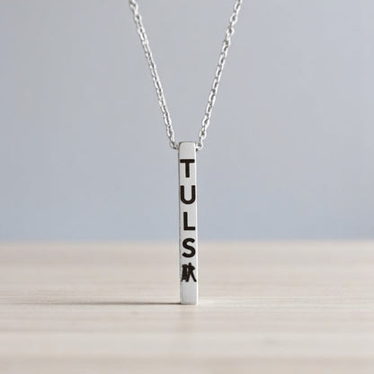 Detail of silver bar pendant engraved with TULSA and Driller symbol, elegant Tulsa-themed jewelry