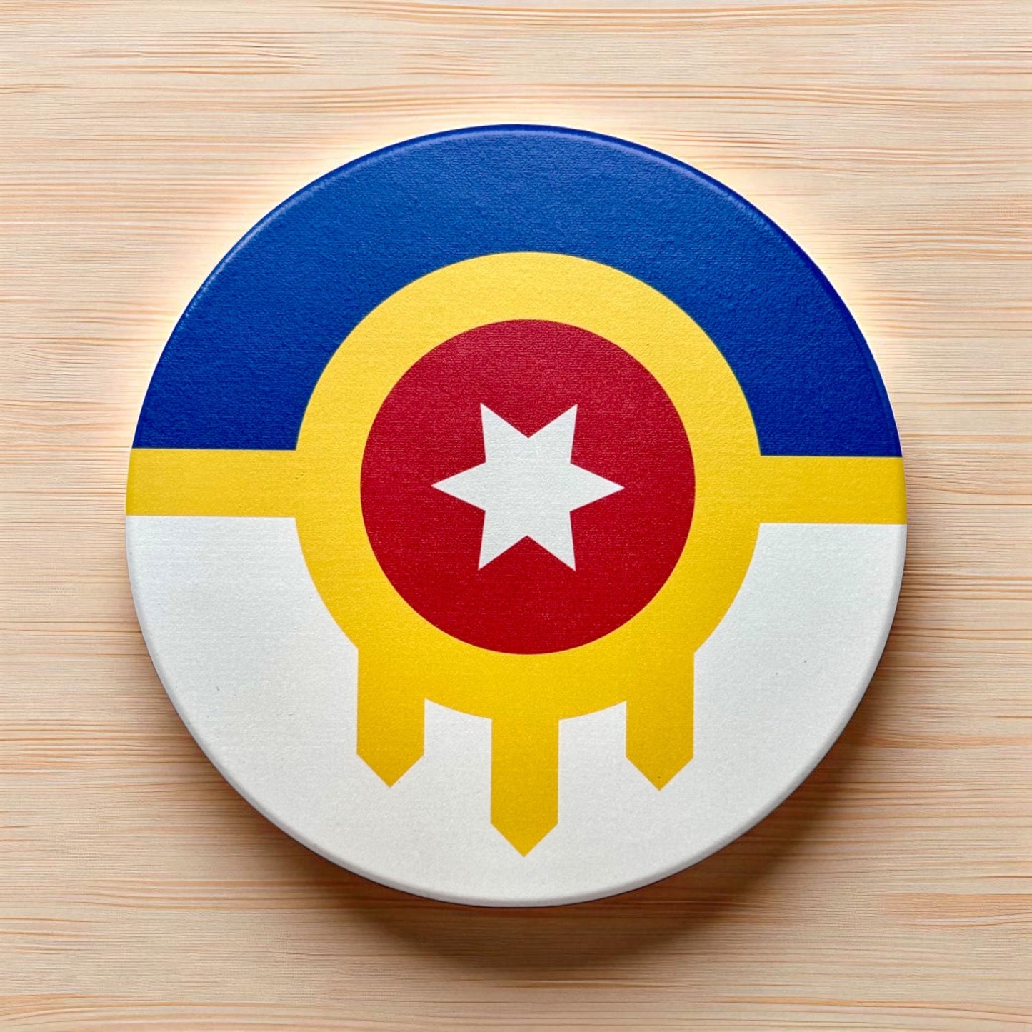 Tulsa flag ceramic coaster displayed on a wood surface, round ceramic Tulsa coaster with city seal design used as an Oklahoma gift or travel souvenir