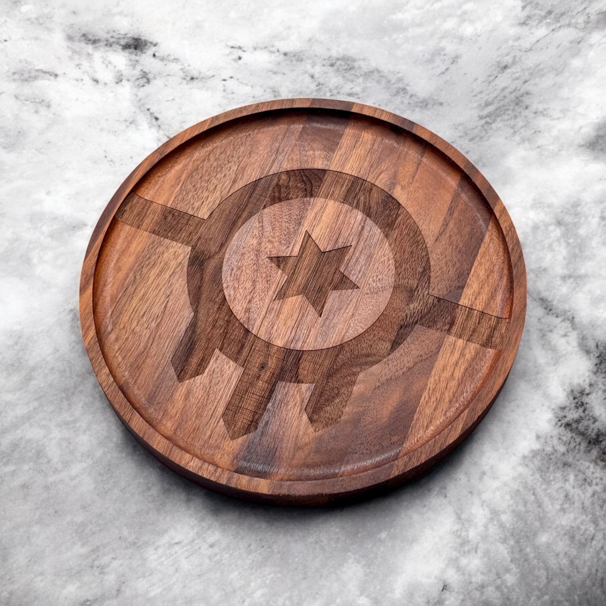 Angled view of a round walnut tray with laser engraved Tulsa flag design, handmade walnut tray styled on a marble surface