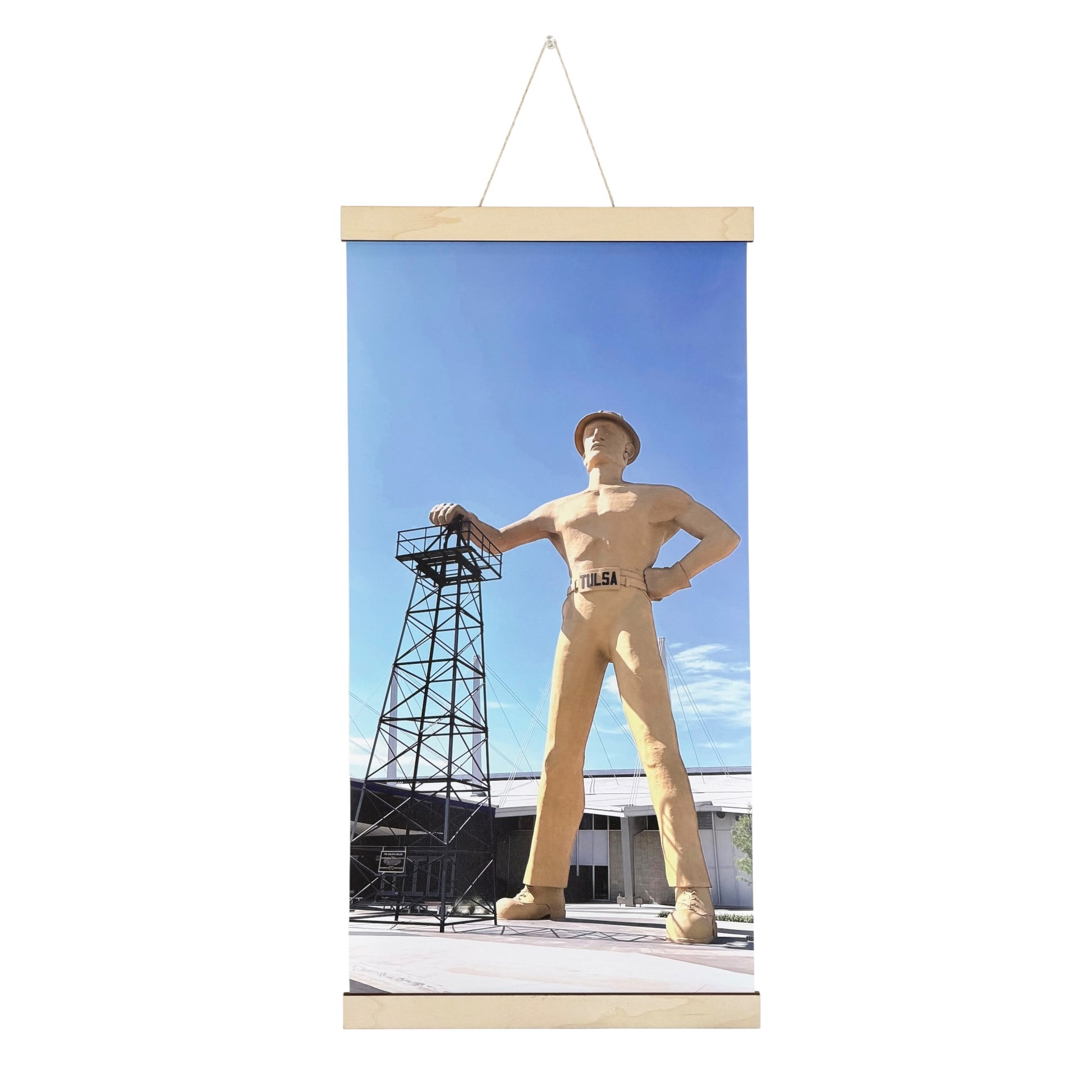 Tulsa Golden Driller canvas wall hanging featuring original Oklahoma photography of the landmark statue beside an oil derrick under a blue sky with natural wood hanging rails