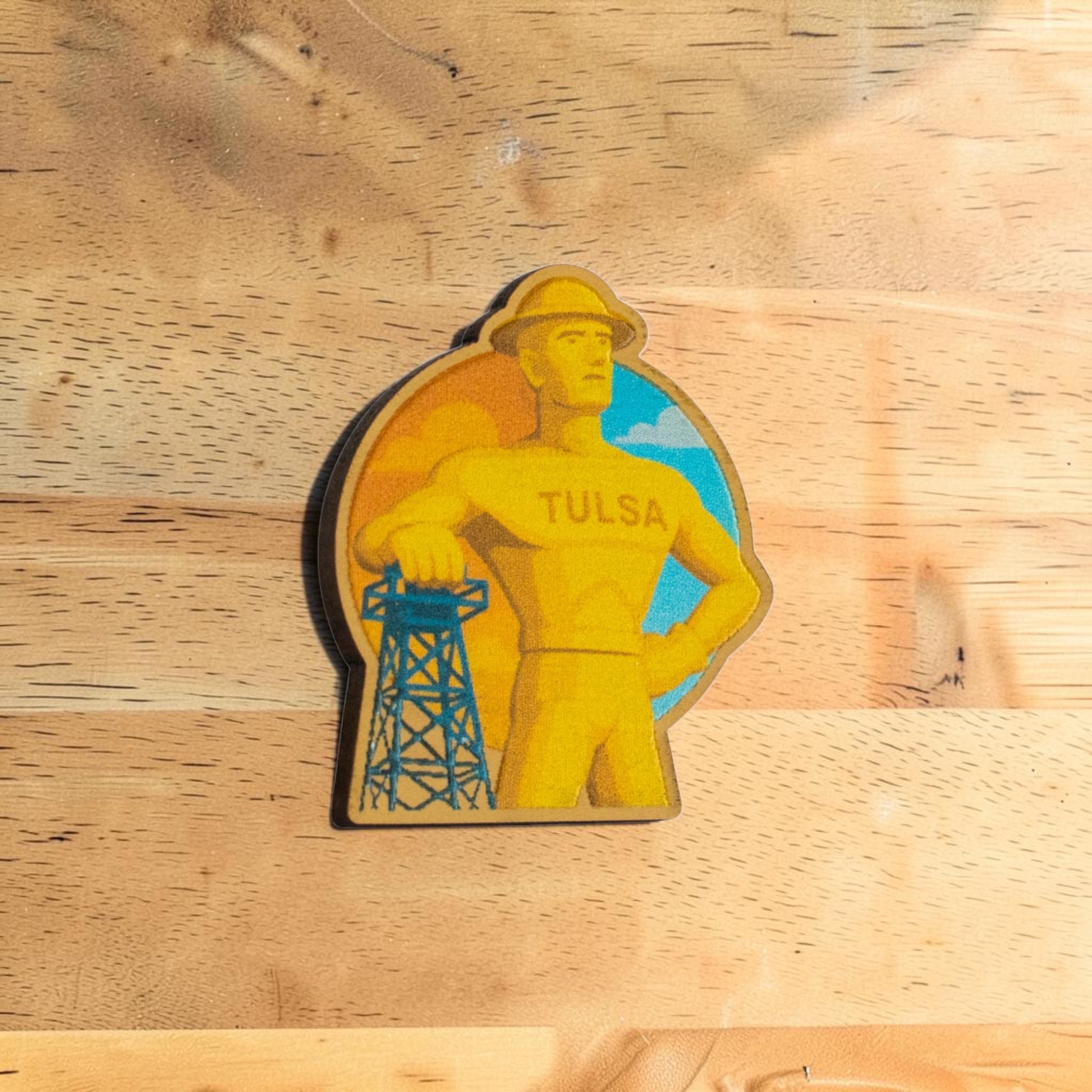 Tulsa Golden Driller wooden souvenir lapel pin isolated on white background showing colorful Tulsa landmark design