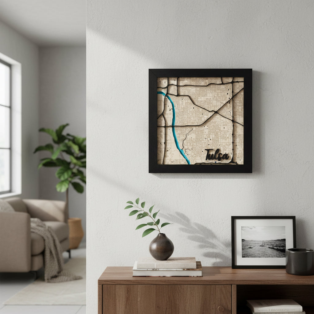 Framed Tulsa layered wood city map wall art displayed on light colored wall above wooden console table, detailed street layout with blue Arkansas River and Tulsa script engraving, modern Tulsa Oklahoma home decor gift and Route 66 travel keepsake