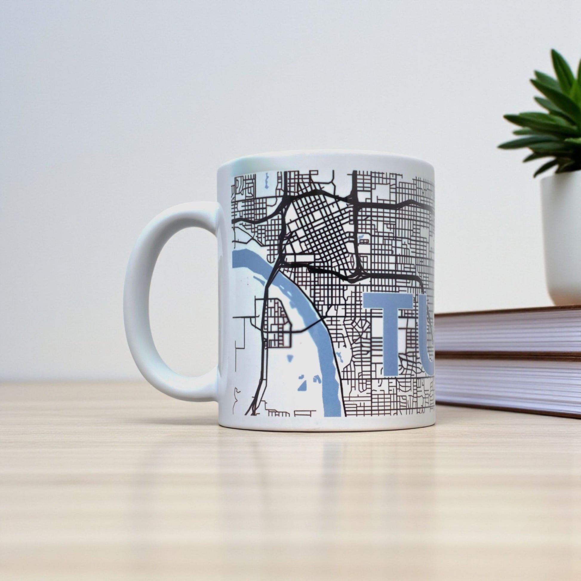 Tulsa map coffee mug on desk with books, white ceramic mug showing detailed Tulsa street grid for local pride or travel gift