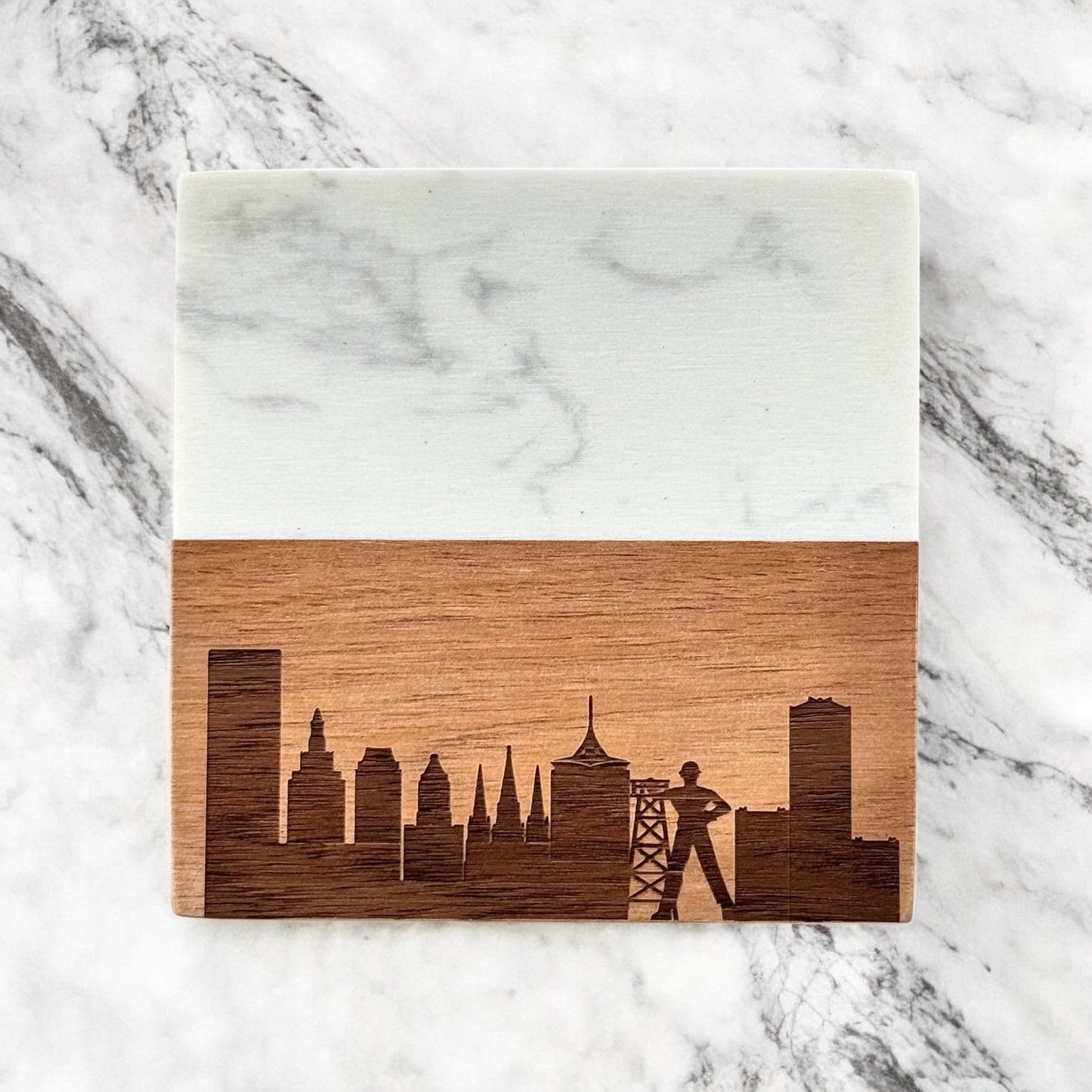 ingle marble and acacia wood coaster featuring laser-engraved Tulsa skyline and Golden Driller, photographed on white marble.