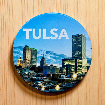 Tulsa night skyline ceramic coaster displayed on a wood surface, round ceramic downtown Tulsa coaster used as an Oklahoma gift or travel souvenir
