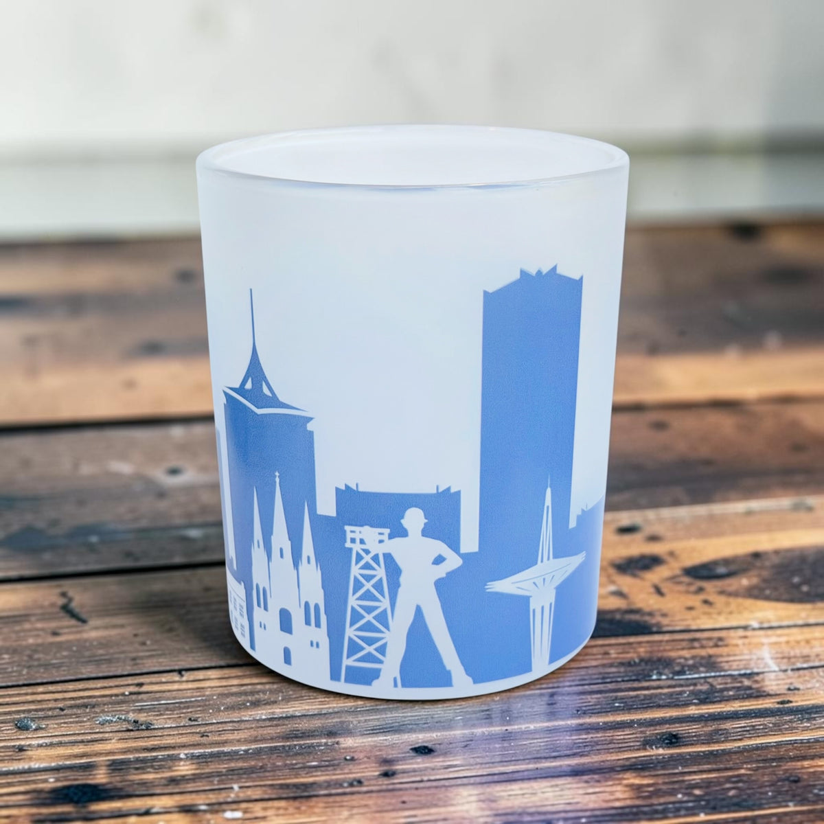 Side view of frosted 8 oz Tulsa Oklahoma lowball glass with blue city skyline and vertical Tulsa lettering, part of a wraparound cityscape souvenir design