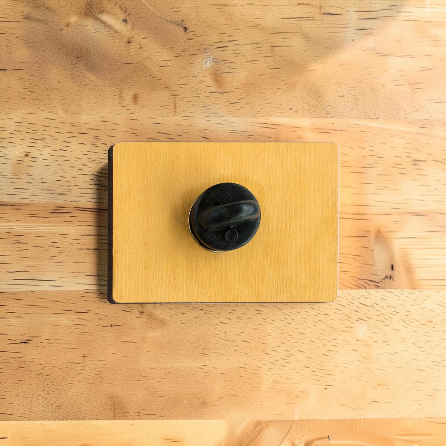 Back side of Tulsa Pride wooden lapel pin showing secure rubber backing on rectangular Eco Wood Birch souvenir pin