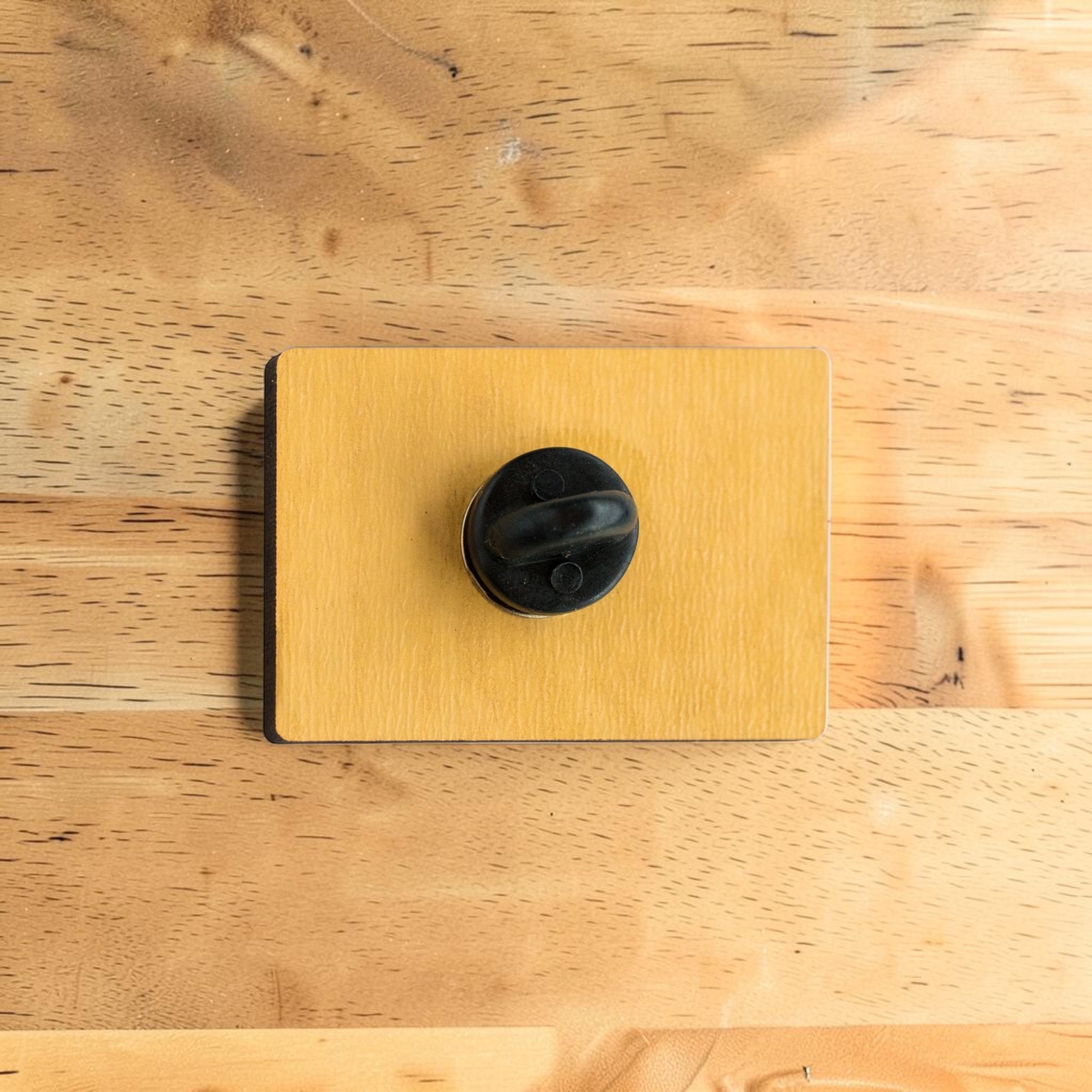 Back side of Tulsa Pride wooden lapel pin showing secure rubber backing on rectangular Eco Wood Birch souvenir pin