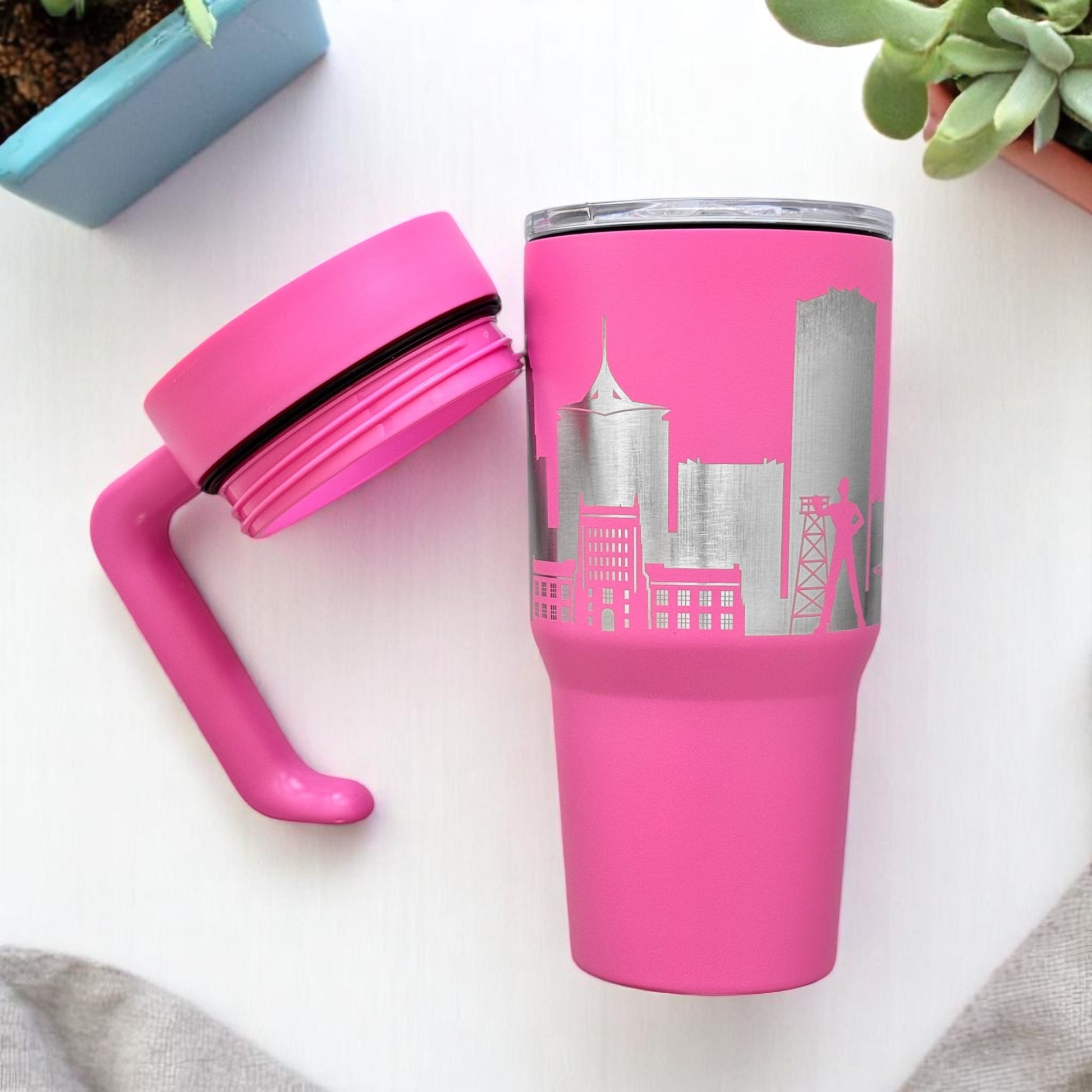 Pink Tulsa skyline insulated travel tumbler flat lay with detachable handle and engraved Tulsa Oklahoma skyline
