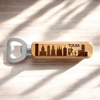 Tulsa skyline bottle opener with engraved wooden handle photographed on light wood surface, Tulsa souvenir and Oklahoma themed bar accessory