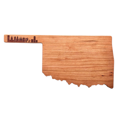 Oklahoma-shaped cherry wood charcuterie board with detailed Tulsa skyline engraving, isolated on a white background