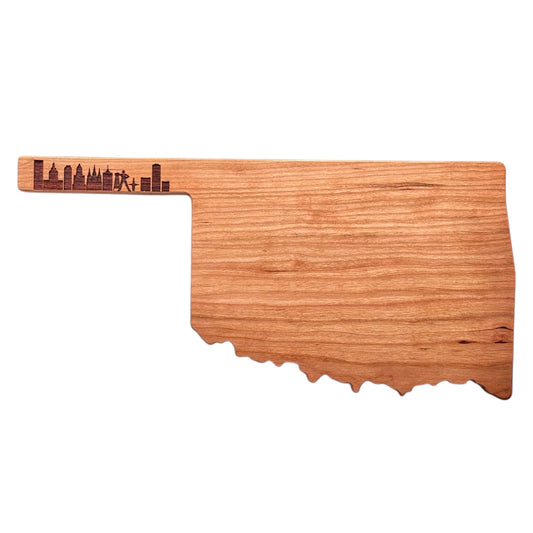 Oklahoma-shaped cherry wood charcuterie board with detailed Tulsa skyline engraving, isolated on a white background
