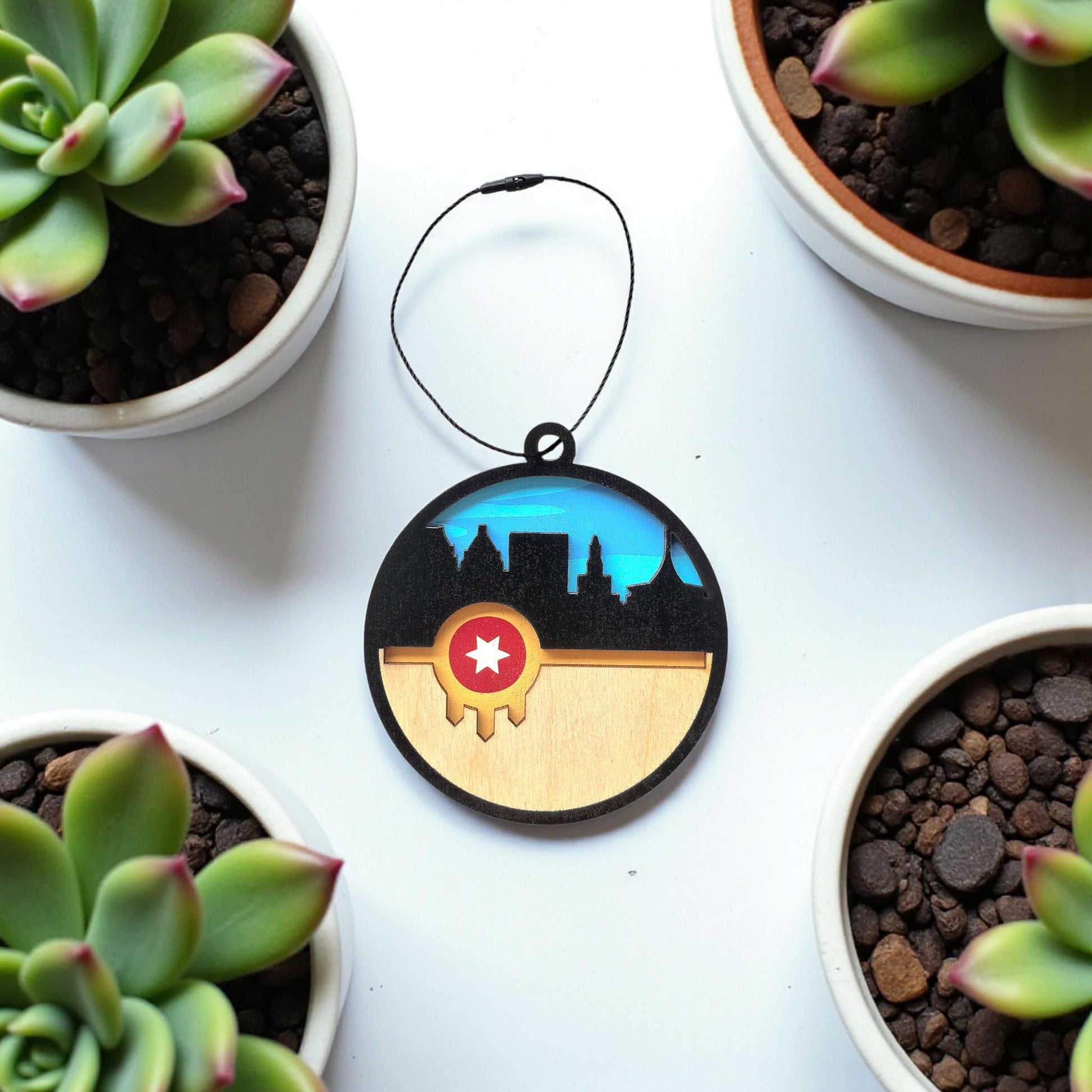 Flat lay of Tulsa flag skyline wooden ornament on white surface with plants, layered wood Tulsa skyline ornament for Oklahoma gift or travel souvenir
