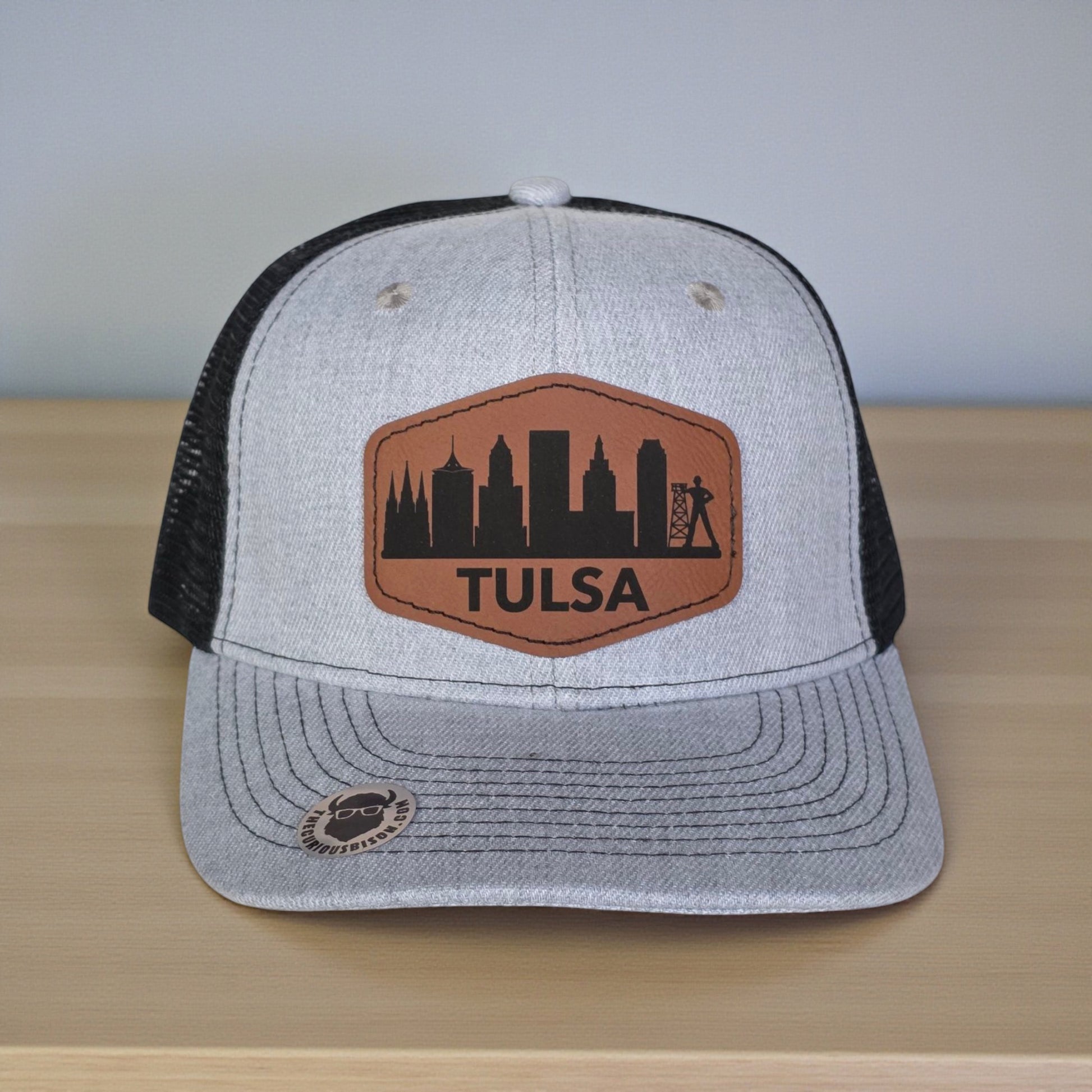 Close up of Tulsa skyline leatherette patch on trucker hat, engraved Tulsa city design with clean stitched edge